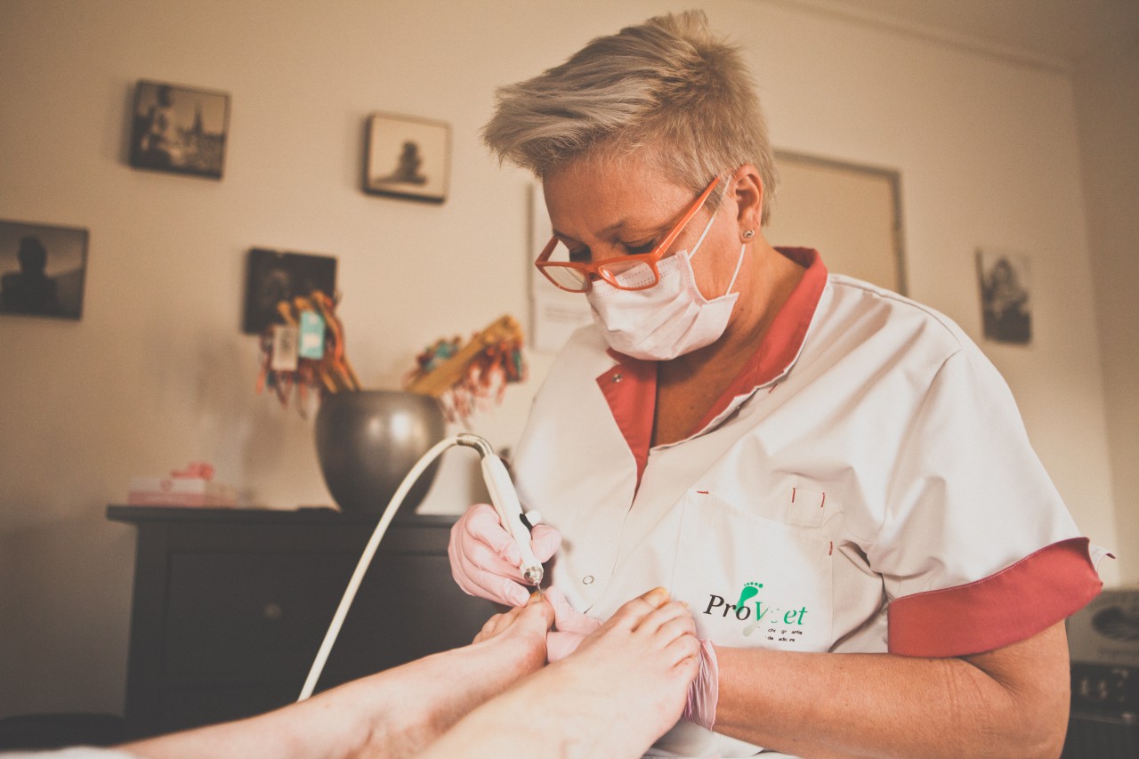 Manita behandelt de nagels van een cliënt in haar praktijk